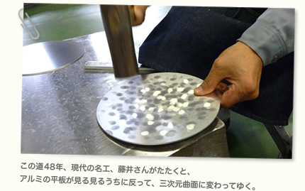 この道年、現代の名工、藤井さんがたたくと、 アルミの平板が見る見るうちに反って、三次元曲面に変わってゆく。