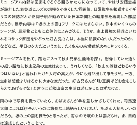 ミュージアム内部は回廊をぐるぐる回るかたちになっていて、やはり安藤忠雄が設計した表参道ヒルズの規模を小さくした雰囲気。日露戦争を報道するイギリスの雑誌だとか正岡子規が勤めていた日本新聞社の編集部を再現した部屋だとか、展示内容は『坂の上の雲』フリークにはたまらない。作中のいくつものシーンが、展示物とともに立体的によみがえる。そうか、史上最強の騎兵といわれるコサック師団をやぶった好古兄さんは、本当に私欲のない人だったのか、平日の夕方だというのに、たくさんの来場者が次々にやってくる。  ミュージアムを出て、路地に入って秋山兄弟生誕地を探す。想像していた通りの細い路地に秋山兄弟の生家はあって、うれしくなる。「秋山の淳ほどわるいやつはいない」と言われたガキ大将の真之が、今にも飛び出して来そうだ。一方、生家は想像よりはるかに大きな家だった。好古兄さんが「お豆腐ほどお金をこしらえてあげるぞな」と言うほど生活は苦しかったはずだけど。  雨の中で写真を撮っていたら、おばあさんが傘を差しかざしてくれた。司馬遼太郎によれば伊予というのは悠長な土地柄らしいけれど、たぶん人柄もいいのだろう。坂の上の雲を探そうと思ったが、雨なので坂の上は雲だらけ。ま、目的は達成したということで。